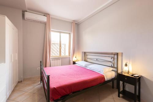 Un dormitorio con una cama grande con una manta roja. en Dream House Fiumicino, en Fiumicino