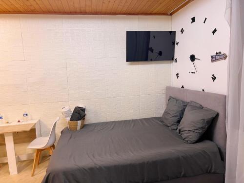 a bedroom with a bed and a white wall at Magnifique Studio de 20m2 pour 1 à 4 personnes in Les Rousses
