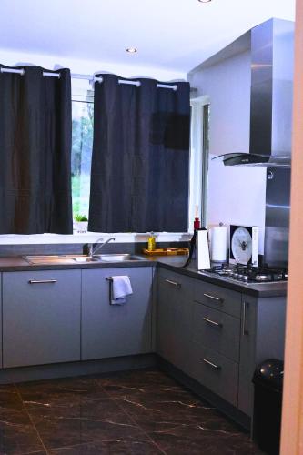 a kitchen with a sink and a stove and a window at A beautiful spacious brand-new 3 Bed Guest house in Oxford City - 10mins walk to Oxford Hospitals in Oxford
