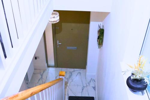 a hallway with a door and a staircase with marble floors at A beautiful spacious brand-new 3 Bed Guest house in Oxford City - 10mins walk to Oxford Hospitals in Oxford