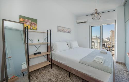 a bedroom with a large bed and a window at Mandilara Minimal Apartment in Rhodes Town