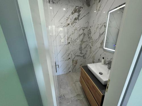 a bathroom with a sink and a mirror at Hilltop Villa in Shetaj