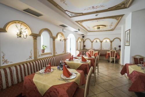 uma fila de mesas num restaurante com toalha de mesa vermelha em Albergo Fiordaliso em Canazei