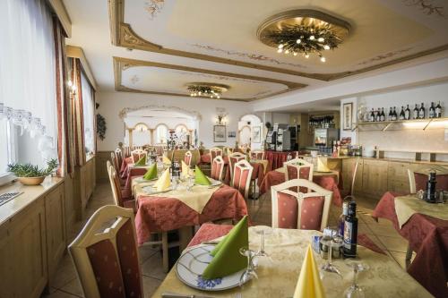 um restaurante com mesas e cadeiras em uma sala em Albergo Fiordaliso em Canazei
