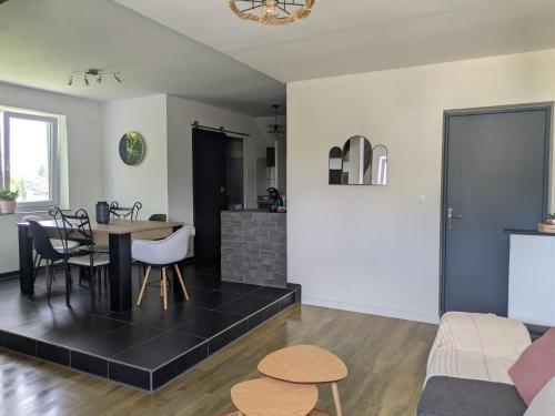 a living room and kitchen with a table and chairs at Au jardin des pies in Woustviller