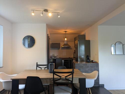 a kitchen and dining room with a wooden table and chairs at Au jardin des pies in Woustviller