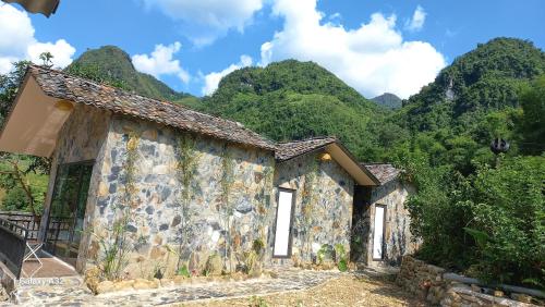 a building with mountains in the background at Du Gia NaLien View Homestay in Làng Cac