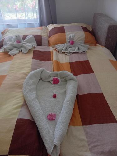 two beds with towels and a heart on them at Hagyományőrző és múltidéző porta in Báta