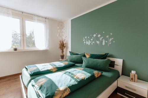 two beds in a bedroom with blue walls at Die Triniushütte "Thüringens schönste Aussicht" in Rauenstein