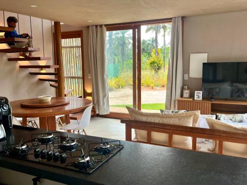 マラウにあるVila Shangrilá Ponta do Mutá, condomínio de charmeのキッチン、リビングルーム(コンロ、テーブル付)