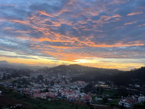ein Blick auf eine Stadt bei Sonnenuntergang in der Unterkunft Ooty Dream Weaver cottage in Udagamandalam
