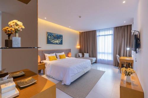 a hotel room with a bed and a living room at Wyndham Garden 3Br Villa 5star Resort Beachfront in Cam Lâm