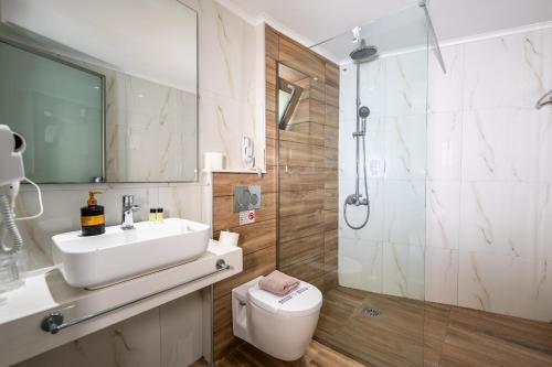 a bathroom with a sink and a toilet and a shower at Marvel Deluxe Rooms in Heraklio Town