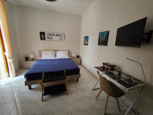 a bedroom with a bed and a desk and a television at Hyria Intero Appartamento in centro città in Avellino