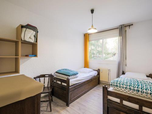 une petite chambre avec deux lits et une fenêtre dans l'établissement Appartement 3 pièces près du centre avec parking et casier à skis - FR-1-689-16, à Villard-de-Lans