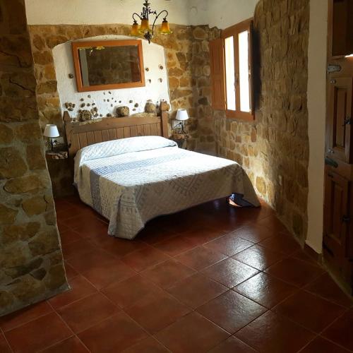 una camera da letto con un letto in un muro di pietra di Casa Alba a Xert