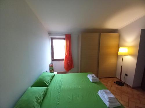 a bedroom with a green bed and a window at VANDA VISTA LAGO Alloggio Turistico in Capodimonte