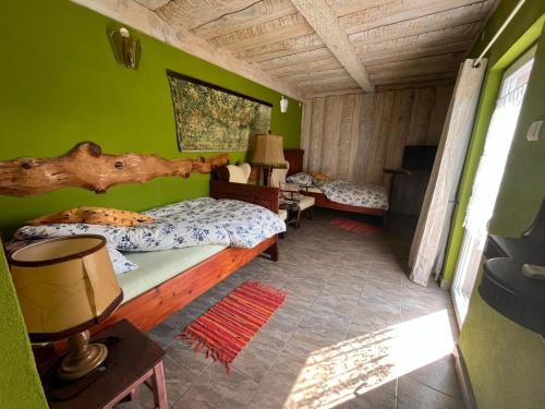 a bedroom with a large bed in a green wall at Šumski Dvori Apartment in Ogulin