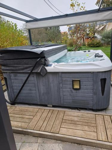 a hot tub sitting on a deck in a backyard at Le Gite de Mamou, grande capacité proche de Strasbourg in Uhlwiller