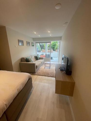 a bedroom with a bed and a couch and a tv at Studio Alexander with private indoor parking in Zandvoort