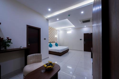 a hotel room with a bed and a table and a chair at T S Royal Grand Hotel in Bengaluru