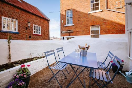 a blue table and chairs on a patio at Bronte's Rest - Detached Elegant Cottage in Historic Old Town with Garden in Scarborough
