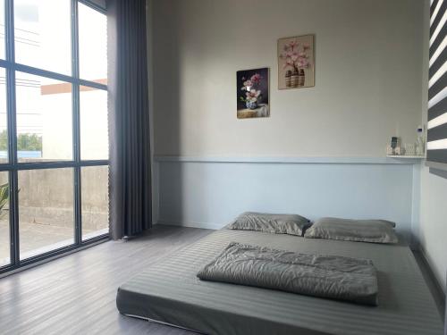 a bed in a room with a large window at Phòng View sân vườn-hồ bơi in Ấp Phú Khương