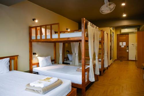 a room with two bunk beds with white sheets at Metro Pratunam Boutique Hotel in Pratunam