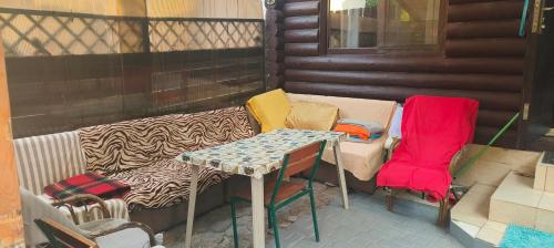 a porch with a couch and chairs and a table at Сдам дом сруб посуточно у моря в Совиньоне с верандой in Odesa