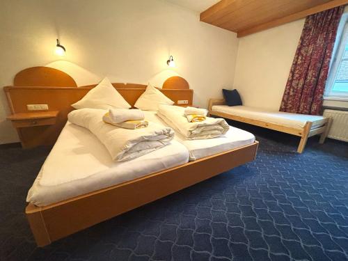 Una habitación de hotel con una cama con toallas. en Gasthof Post, en Stanzach