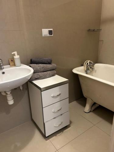 a bathroom with a sink and a tub and a toilet and a sink at Planty Apartament in Kraków