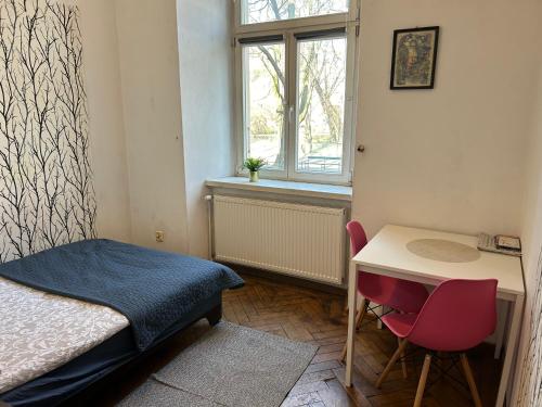 a small bedroom with a desk and a bed and a window at Planty Apartament in Kraków