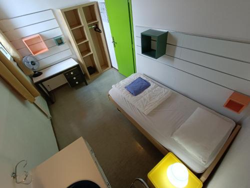 a small room with a small bed and a green wall at Ostello Montebello - Bellinzona Youth Hostel in Bellinzona