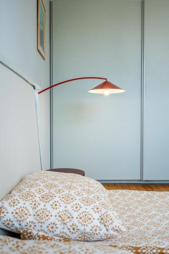 a lamp sitting next to a bed with a pillow at Bright & Central 2BR in Historic Heart of Sofia in Sofia