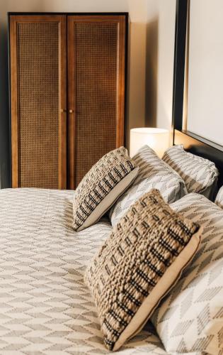 a bed with four pillows on top of it at Boho Bay One - Seaside Escape in Cullercoats