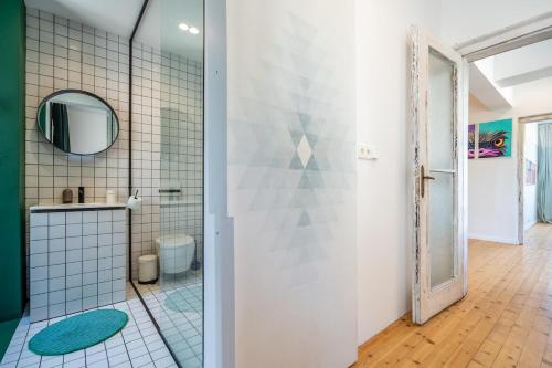 a bathroom with a shower with a toilet and a mirror at Bright & Central 2BR in Historic Heart of Sofia in Sofia