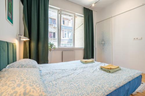 a bedroom with a bed with two towels on it at Bright & Central 2BR in Historic Heart of Sofia in Sofia