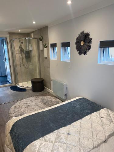 a bedroom with a large bed and a shower at OneDouble room, one small double room, one en-suite studio room near to Wembley stadium in London