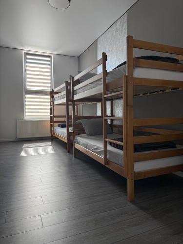a room with three bunk beds and a window at Hotel Hostel Перехрестя in Chistilov