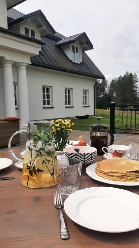 a wooden table with plates and utensils in front of a house at Dawno Temu - Agroturystyka Premium in Lipowy Most