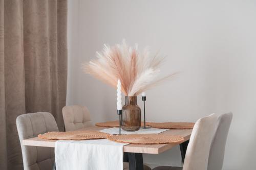 a dining room table with a vase with feathers on it at Aegean Nest in Mytilini