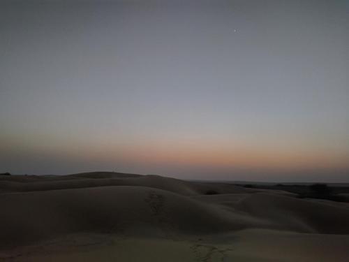 a sunset over the sand dunes in the desert at Jaisalmer Rosu Safari in Jaisalmer