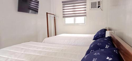 a bedroom with two beds and a window at Leribi Suites and Restaurant in Ulot