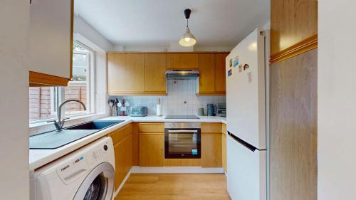 a kitchen with a white refrigerator and a dishwasher at 3 Bed House with parking and garden near Tower Bridge in London