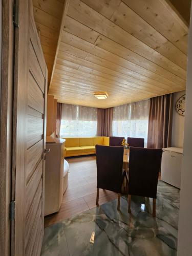 a living room with a table and a yellow couch at Wellness Toliar Tatry in Stará Lesná