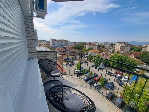a balcony with two chairs and a view of a parking lot at T&M Apartman in Paraćin