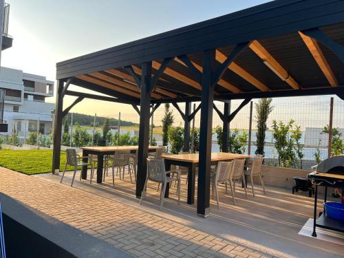 a wooden pavilion with tables and chairs on a patio at Vila Marbo in Baile Felix