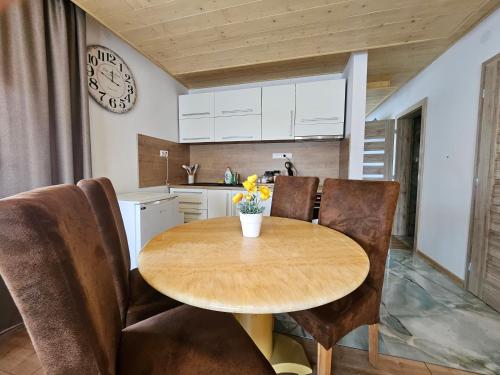 a kitchen with a table and chairs and a clock at Wellness Toliar Tatry in Stará Lesná