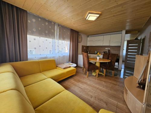 a living room with a yellow couch and a table at Wellness Toliar Tatry in Stará Lesná