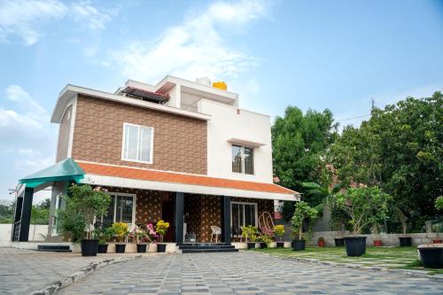 a house on a cobblestone street at Grandir Inn Villa in Mahabalipuram